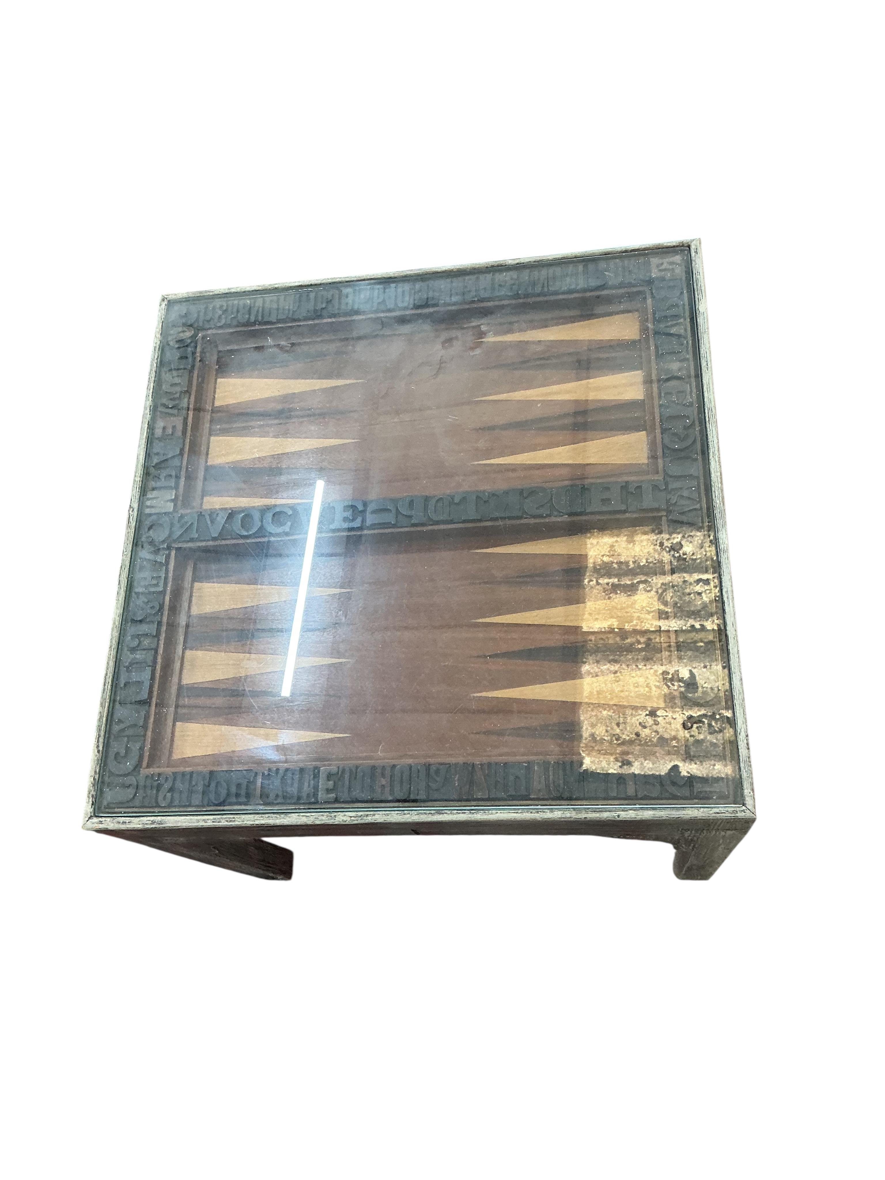 A pair of grey painted printing block inset lamp tables, one with backgammon board, width 47cm, depth 47cm, height 42cm